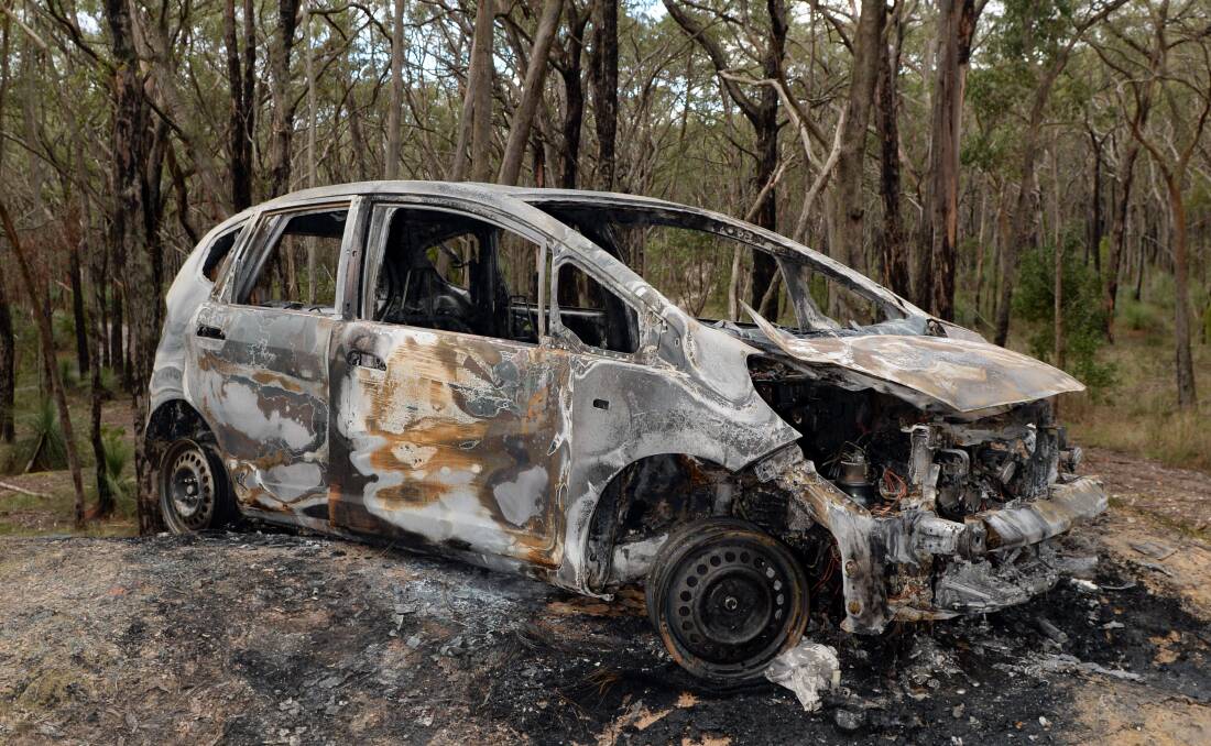 Burnt to a crisp: The stolen car of a 92-year-old woman was found smouldering in the Canadian State Forest on Thursday morning. Picture: Kate Healy