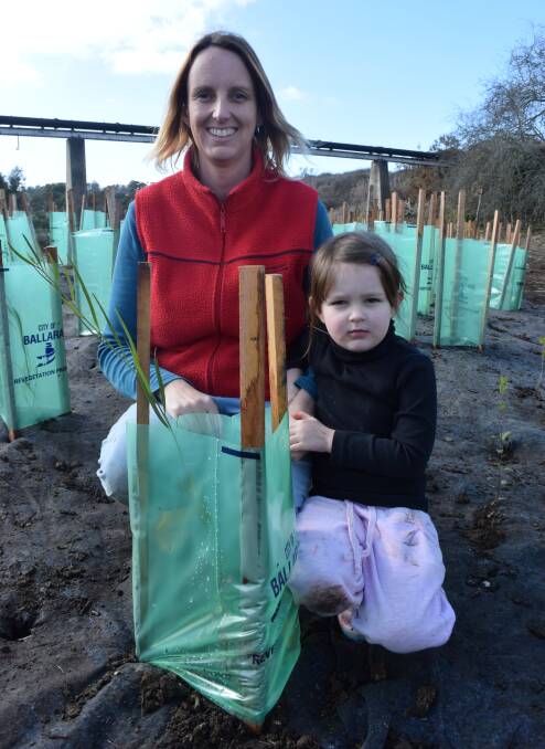 Jane Bevelander and Abigail, 4 help plant trees along the Yarrowee River.