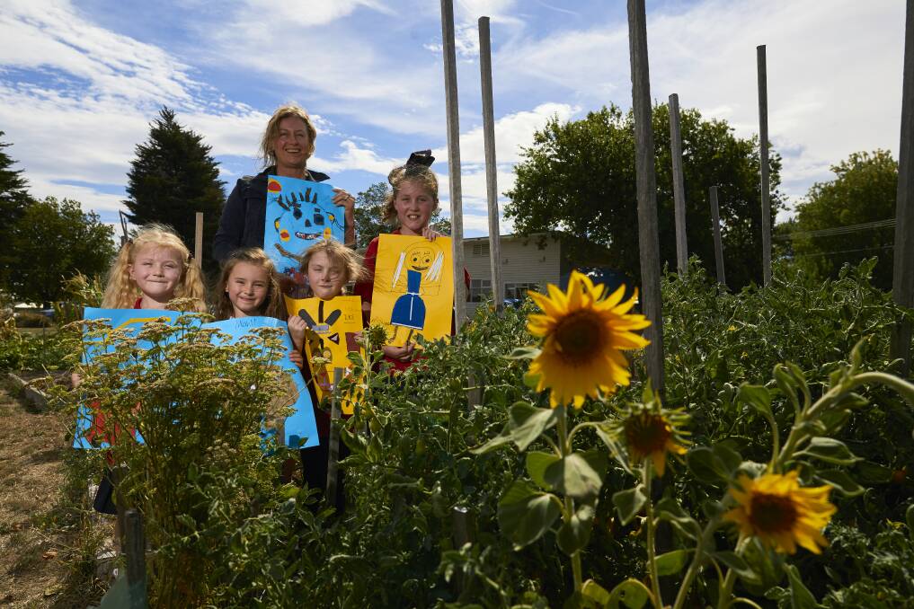 THINK GREEN: Jane Rabl, 5, Zara Smith, 5, Kate Rabl, 7, and Ella Rabl, 9, with art teacher Michelle Noyce at the Buninyong community garden. Their art will be presented at the Smart Building and Living Expo. Picture: Luka Kauzlaric