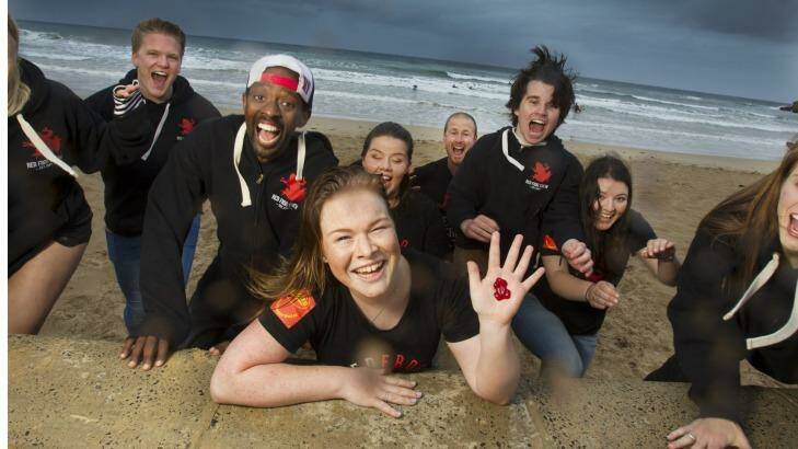 Brianna van't Hag (front, with Red Frog lolly) and fellow Red Frogs volunteers relax at Torquay in the lead-up to Victorian schoolies celebrations. Photo: Simon O'Dwyer