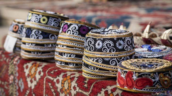Taqiyah, traditional muslim hats placed on a typical carpet sold on a local market in Icheri Sheher (Old Town) in the Center of Baku.  Photo: iStock