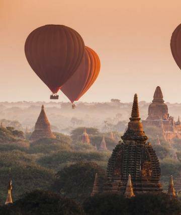 Hot air balloons float over the plain of Bagan on a misty morning in Myanmar. Photo: Noppakun Wiropart