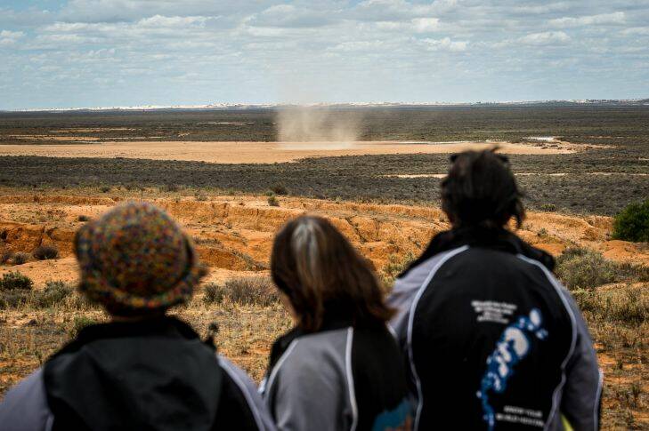 The Age, News, 17/11/2017, photo by Justin McManus.
Repatriation of Mungo Man's remains along with 104 other ancient ancestors back to conutry at Lake Mungo. The remains will be taken from thre National Museum of Australia's  storage faciclity in Canberra in the old Aboriginal hearse accompanied by elders from the Willandra region - the Mutthi Mutthi, Paakantyi?????? and Ngiyampaa?????? people. They will travel and be welcomed with ceremony from local elders at Wagga Wagga, Hay and Balralnald before being laid to rest at Lake Mungo.
Elders watching a wirly wirly over the lakes.