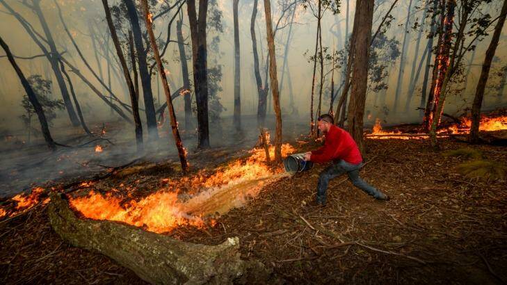 Ross Upfield fighting the fire to save his friend's home. Photo: Justin McManus