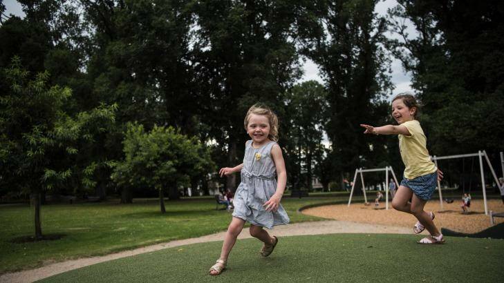 Sisters Ruby and Evie play in the Carlton Gardens. Photo: Josh Robenstone