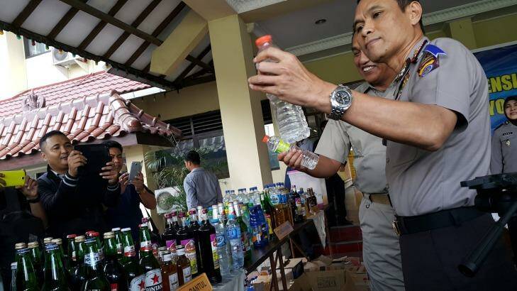 The Yogyakarta deputy police chief holding a bottle containing deadly bootleg alcohol at a press conference in Yogyakarta earlier this month.  Photo: Amilia Rosa