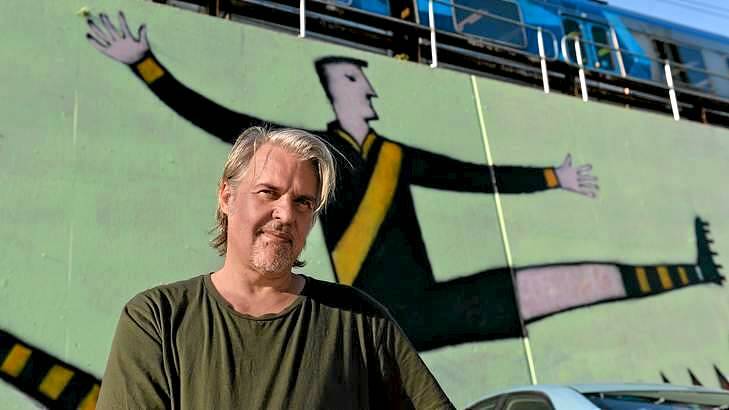 Artist Nick Howson in front of  a mural he painted next to Richmond Station, which he titled Tiger Legend. Photo: Justin McManus