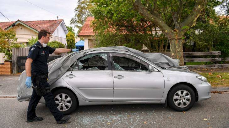 Crime Scene Officer Glen Finlay with a vandalised Toyota on Chaucer Avenue. Photo: Eddie Jim