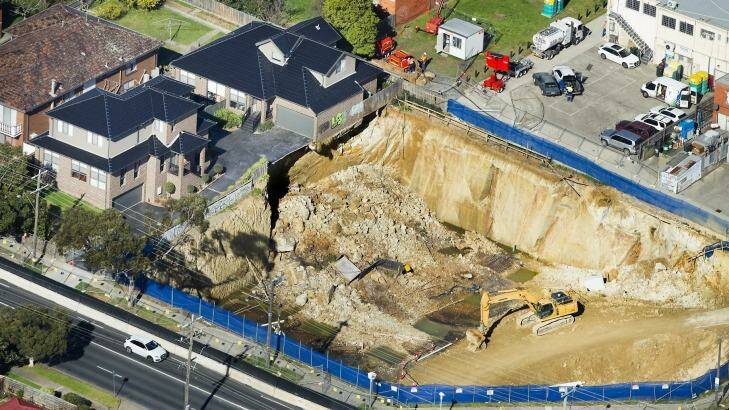 Two townhouses sit on the edge of a crumbling construction pit on the corner of Huntingdale and Highbury Roads, Mount Waverley. All practitioners involved are under investigation. Photo: Simon O'Dwyer