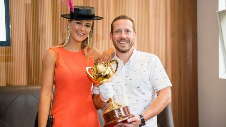 Myer Fashions on the Field ambassador Stephanie Smith and Huxtaburger owner Daniel Wilson with the Melbourne Cup.  Photo: Karon Photography