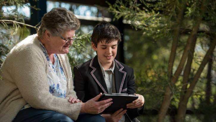 Ben, a student at Mount Eliza Secondary College teaching Jann Bell how to listen to the radio via her iPad.  Photo: Penny Stephens
