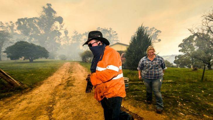 Residents Adam Watkin and Prue Mathisen fight to save their home near Lancefield on Monday. Photo: Justin McManus