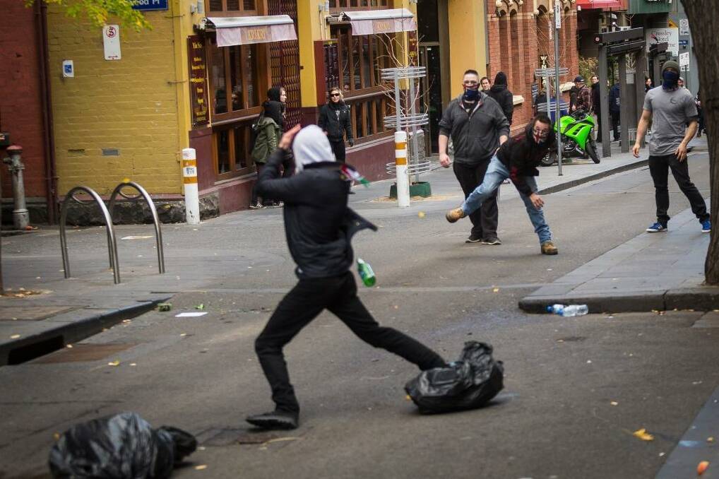 Members of the United Patriot Front throwing a bottle at a counter-protester. Photo: Chris Hopkins