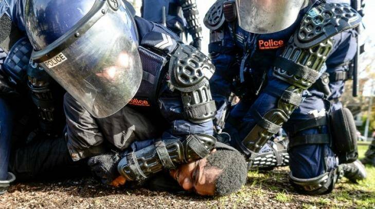 Police tackle a protester to the ground during the rally in Fitzroy Gardens.  Photo: Justin McManus