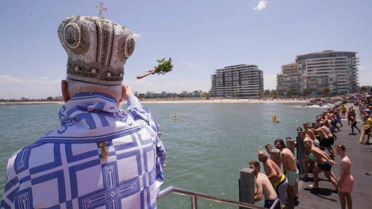His Grace Bishop Ezekiel of Dervis throws the cross into the water during The Blessing of the Waters at Princes Pier in Port Melbourne. Photo: Darrian Traynor