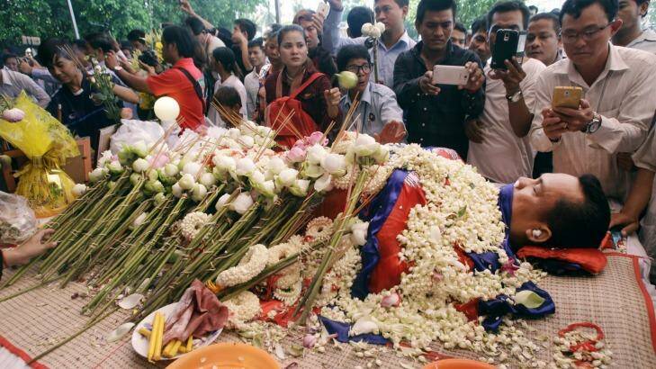 The body of Cambodian government critic Kem Ley is covered by the Cambodian National flag as flowers are placed during a funeral ceremony in Phnom Penh. Photo: Heng Sinith