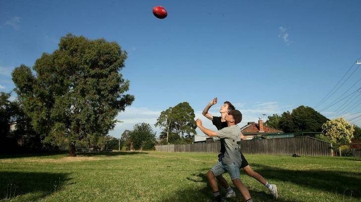 Boys play football on the Reservoir land Melbourne Water wants to rezone and sell.  Photo: Pat Scala