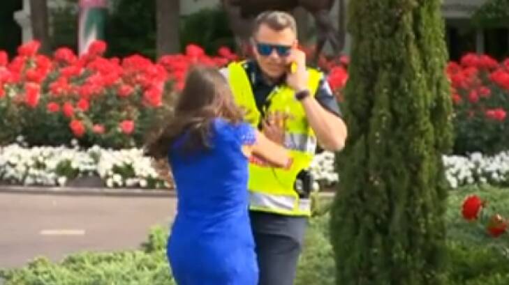 Sarah Finn pushes Acting Superintendent Steven Cooper into a bush at Flemington on Melbourne Cup Day. Photo: Channel Seven