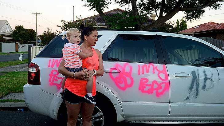 Residents in Challis Street awoke to find a trail of destruction left by teenage vandals. Katherine Clark, who is holding her friend's daughter Isabel, surveys the damage to her car. Photo: Penny Stephens