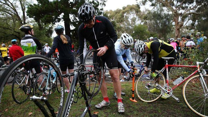 A cyclist fixes a puncture after hitting a tack during a protest that involved over 1000 bike riders who rode 13km's around Kew Boulevard to protest against someone who had been laying tacks on the road. Photo: Paul Jeffers