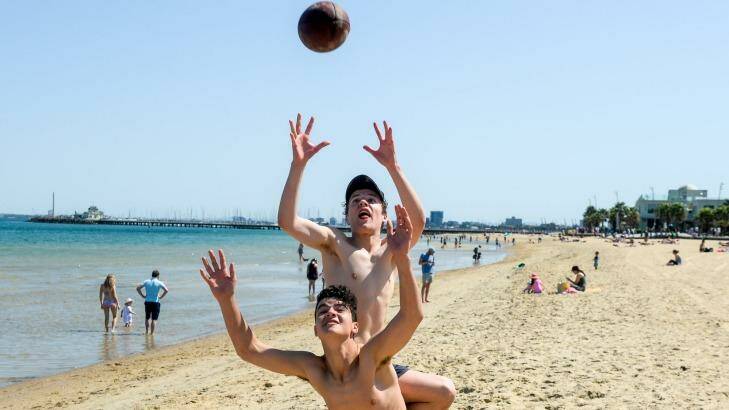 Mates enjoy the sunshine at St Kilda Beach on the grand final public holiday. Photo: Justin McManus