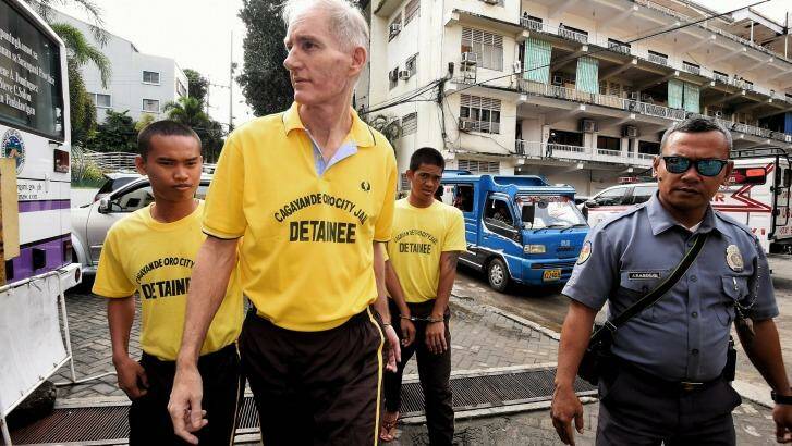 Peter Scully (2nd from left) arrives at the Cagayan De Oro court handcuffed to another inmate on his first day of his trial in September.  Photo: Kate Geraghty
