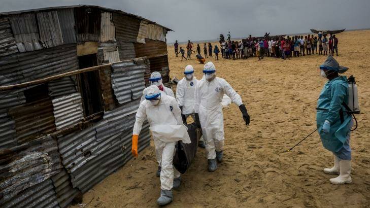 A Liberian Red Cross burial team carries a body of a suspected Ebola victim from West Point in Monrovia. Photo: New York Times