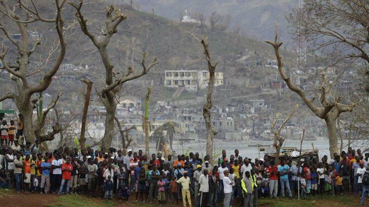 Haitians, hard hit by Hurricane Matthew, await aid from a US helicopter earlier this month. Photo: Rebecca Blackwell
