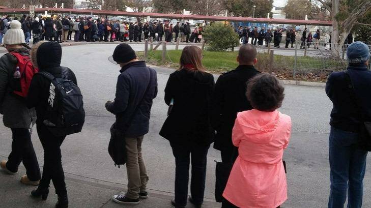 Metro passengers form a long line as they wait for replacement buses at Berwick station. 