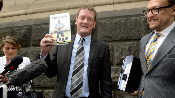 Former AFL player manager Ricky Nixon outside the Court of Appeal  with a copy of his autobiography 'My Side'. Photo: Penny Stephens