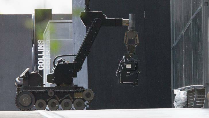 A bomb squad robot investigating the package that turned out to be a pair of shoes. Photo: Jason South