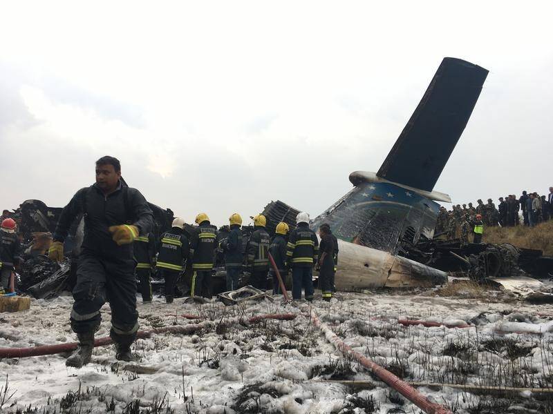 The plane caught fire just before it landed and skidded to a stop in a field beside the runway.