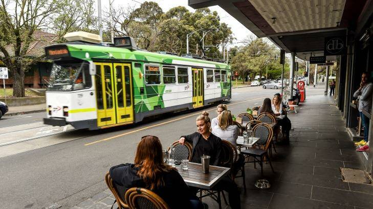 The number 8 tram passes a cafe on Domain Road. Photo: Justin McManus