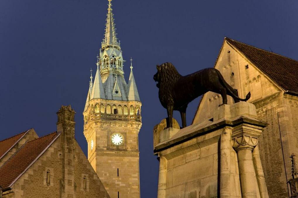 A 12th-century bronze lion at Braunschweig castle square, with the town hall in the background.   Photo: H. & D. Zielske