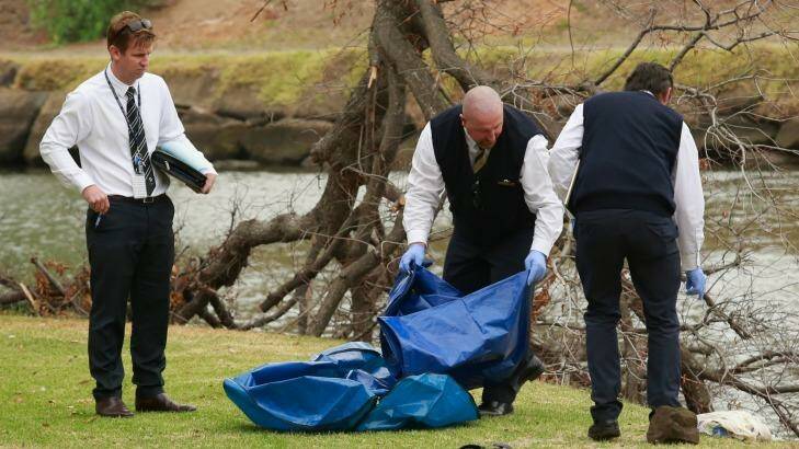 Police investigating the death of Brendan Bernard take away evidence from the banks of the Maribyrnong River.  Photo: Chris Hopkins
