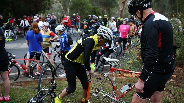 A cyclist fixes a puncture after hitting a tack on Kew Boulevard - during a protest involving over 1000 riders protesting against someone laying tacks on the road. Photo: Paul Jeffers