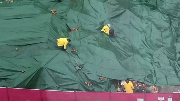 Workers at the Carlton site put tarpaulins over the remains of the pub.  Photo: Supplied
