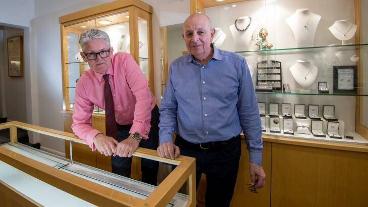 IMP Jewellery owners Denis Kelleway and Tony Fialides with one of the cabinets that was smashed with a machete when they were robbed back in October. Photo: Penny Stephens