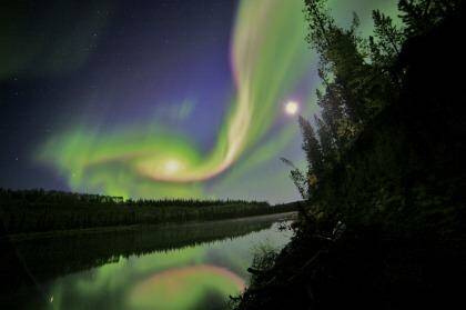 Swirls of green and red appear in an aurora over Whitehorse, Yukon.
