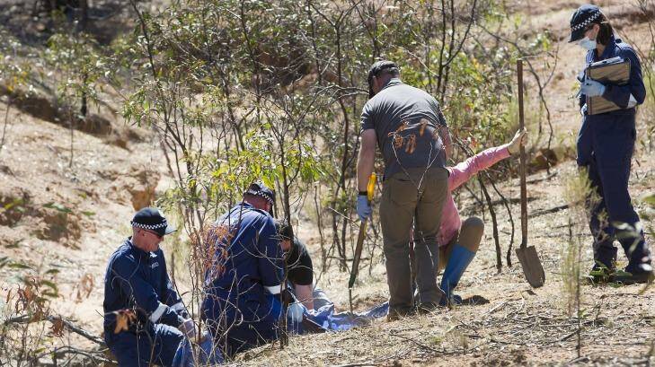Police uncover a body buried next to a creek bed near Bendigo on Friday. Photo: Simon O'Dwyer