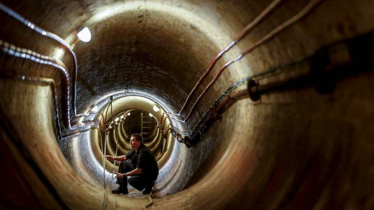 Electrician Glenn Kelly works in the 1890s ventilation tunnel under Victoria's Parliament House. Photo: Eddie Jim