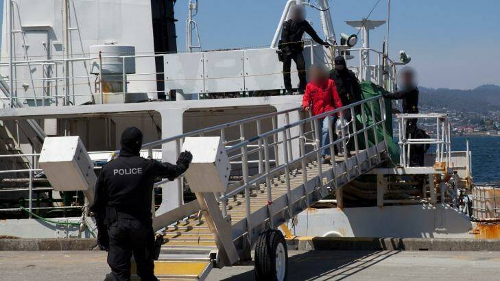 Police lead members of the former whaling vessel's crew away at Hobart in December. Photo: Australian Federal Police