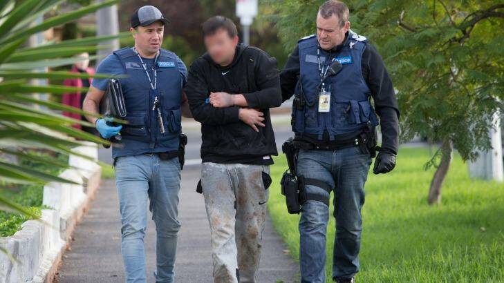 Police lead a man arrested in St Albans to a house in Essendon where further searches were carried out in May.  Photo: Jason South
