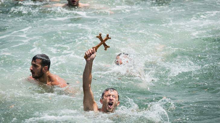 George Noulas 22, of Avondale Heights reaches the cross first at the annual Blessing of the Waters Festival. Photo: Chris Hopkins