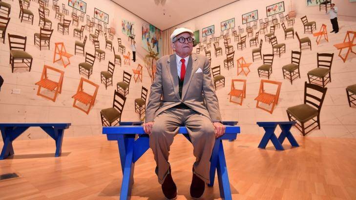 Hockney with his work <i>4 blue stools</i>, 2014, featuring wallpaper comprised of stitched-together digital images. Photo: Joe Armao