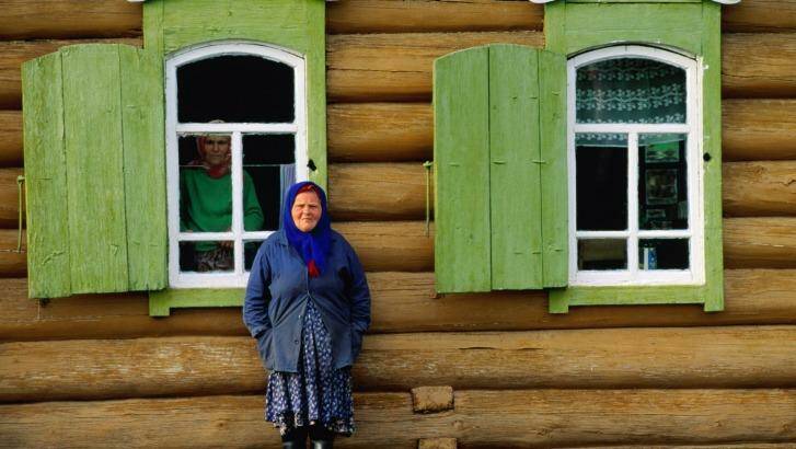 A Woman stands in front of a house in Novosibirsk, Russia. Photo: Peter Solness