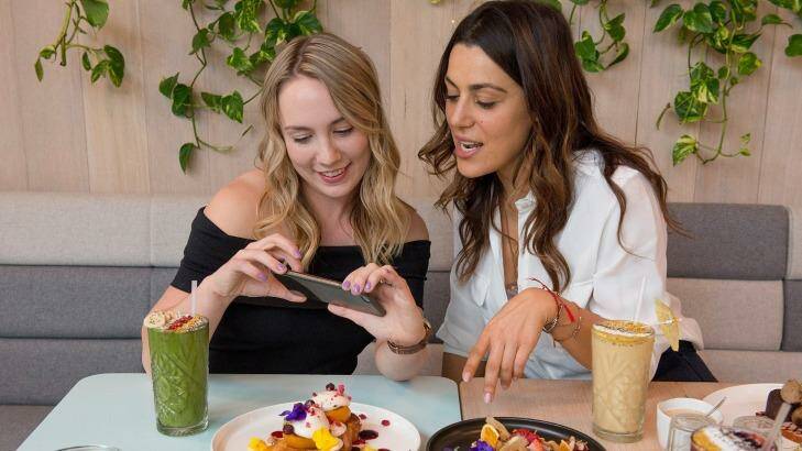 Jackie Doran, left, from Yelp, and Josephine Pulitano, manager at Kitty Burns eatery in Abbotsford, compare food photography notes. Photo: Jesse Marlow