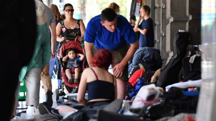 A mother and child pass the homeless people camp along Flinders Street.  Photo: Joe Armao