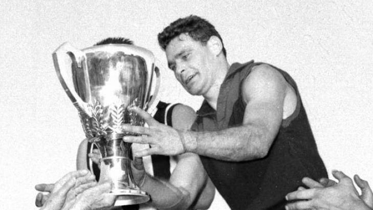 Melbourne's Ron Barassi receives the 1964 premiership cup.