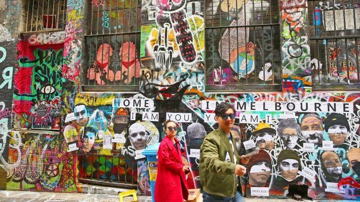 People walk past walls adorned with graffiti in Hosier Lane, one of Melbourne's iconic laneways. Photo: Scott Barbour